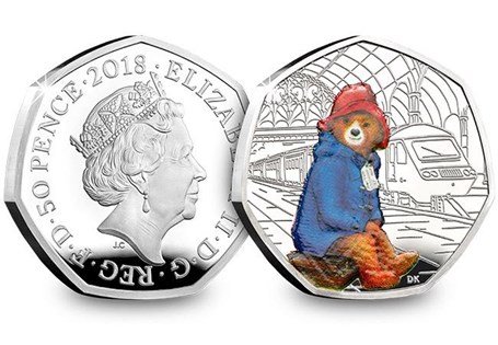UK 2018 Silver Proof Paddington Bear at Paddington Station, issued to celebrate the 60th anniversary of Paddington Bear. The reverse design features Paddington wearing his famous duffle coat. 