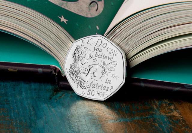 The 2020 Official Peter Pan 50p Coin Reverse leaning against open book